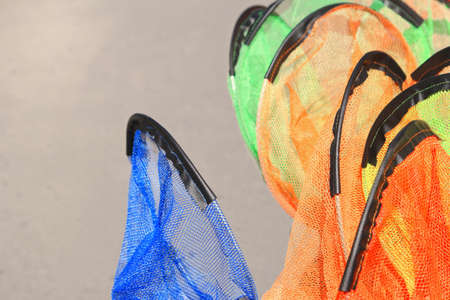 Kids fishing nets stacked for sale, orange, blue, green,shallow focus
