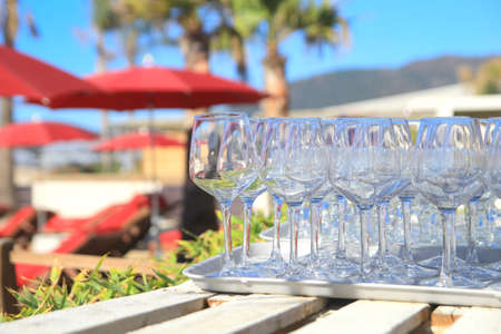 Wine glasses on a wooden table in a tropical paradise beach bar and restaurant