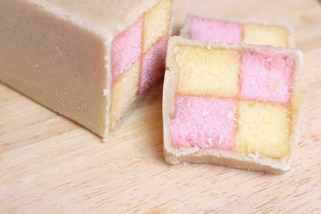 Freshly cut Battenberg Cake with pink and yellow sponge covered in marzipanの写真素材