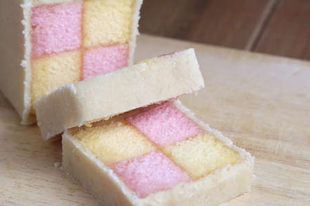 Freshly cut Battenberg Cake with pink and yellow sponge covered in marzipanの写真素材