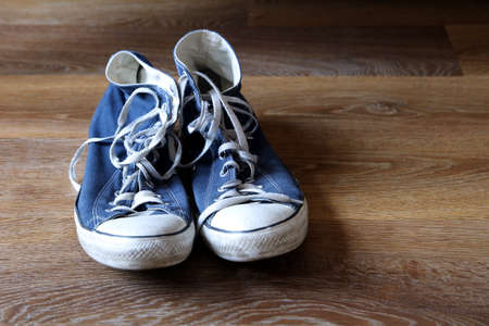 Pair of blue and white sneakers trainers boots on wooden background with space for textの写真素材