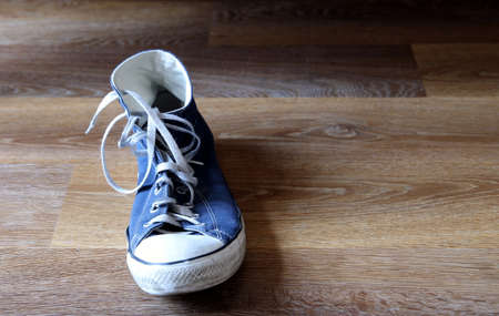 Classic blue and white sneaker, or trainer,or basketball boot on wooden background with space for textの写真素材