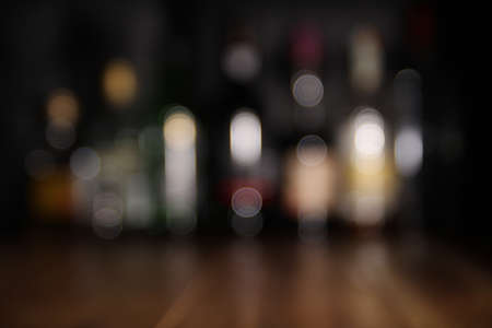 Blurred background of spirit bottles on a wooden barの写真素材
