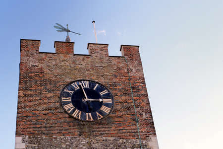 Clock tower and weather vane of an old churchの写真素材