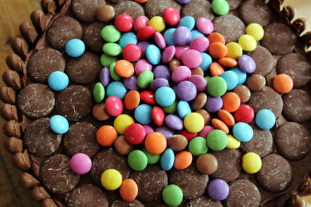 Chocolate cake covered in chocolate fingers, chocolate buttons and chocolate beans
