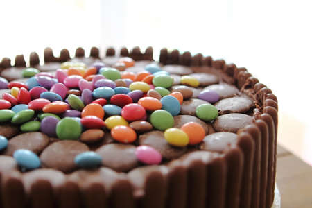 Chocolate cake covered in chocolate fingers, chocolate buttons and chocolate beans