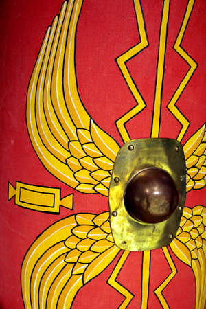 Detail of a reproduction Roman scutum shield with red and yellow wing patternの写真素材