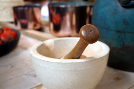 Shallow focus image of a vintage mortar and pestle in a rustic table settingの写真素材