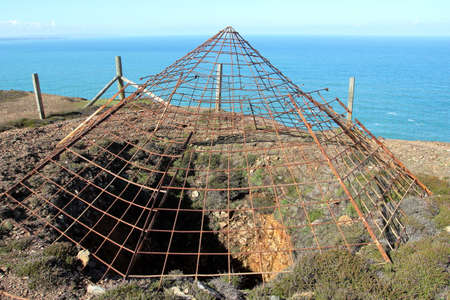 Steel protective grid covering the opening of a disused tin mine shaftの写真素材