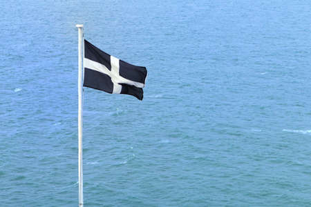 Cornish independence flag flying over the blue oceanの写真素材