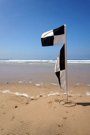 Flag on a deserted beach indicating safe swimming and surfing zonesの写真素材