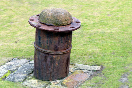 Old steel and concrete boat mooring bollard on stone baseの写真素材