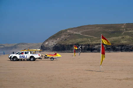 Newquay, Cornwall, UK - April 7 2017: Red and yellow lifeguard flags on the beach for swimmers and surfers, with RNLI Lifeguard truck and jetski in backgroundのeditorial素材