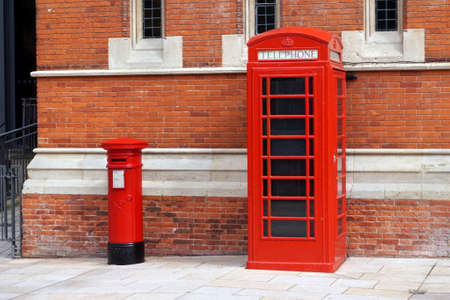 Stratford-upon-Avon, UK - July 21 2017: Iconic British red telephone box and pillar box against a classic red brick wallのeditorial素材