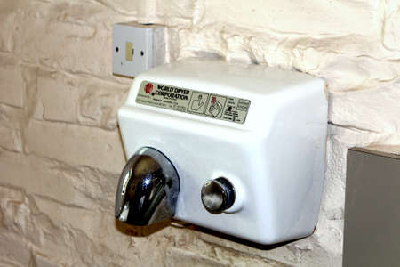 Stratford-upon-Avon, UK - July 23 2017: Classic Warner Howard World Dryer Corporation warm air hand dryer in an old gents toilet or mens roomのeditorial素材