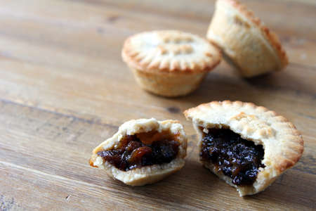 Selection of several mince pies, some broken open or partly eaten. A traditional festive Christmas dessert or pudding.の写真素材