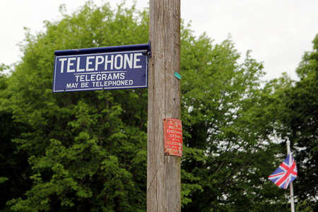 Dorset, UK - May 31st 2016: Vintage British telephone telegraph and telegram signs on a traditional wooden pole.のeditorial素材