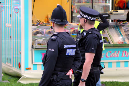Beaulieu, Hampshire, UK - May 29 2017: Rear view of two British police officers at a mobile sweets...