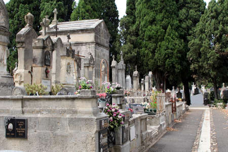 Pezenas, Herault, France - Aug 26 2017: Traditional French cemetery with many crosses, flowers and commemorative plaquesのeditorial素材