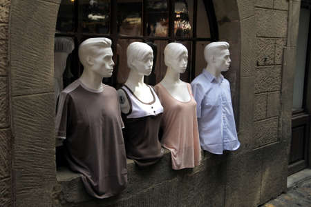 Carcassonne, Languedoc-Roussillon, France - August 24 2017: Two male and two female mannequins, dressed in stylish fashion clothes and posed in the window of an old stone buildingのeditorial素材