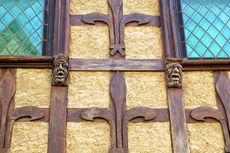 Carcassonne, Languedoc-Roussillon, France - August 24 2017: Unusual carved gothic head features on a tudor style wood framed building wallのeditorial素材
