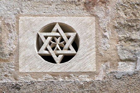 Pezenas, Herault, France - Aug 26 2017: Carved stone Star of David set into a round opening in a stone wall in the Jewish quarter of Pezenas, Languedoc, Franceのeditorial素材