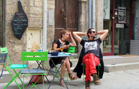 Pezenas, Herault, France - Aug 26 2017: Man and woman hipster couple relaxing at a street cafe table in the Languedoc town of Pezenas, Franceのeditorial素材