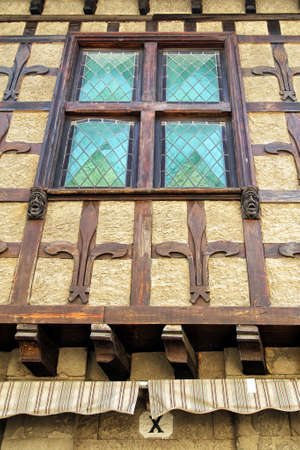 Carcassonne, Languedoc-Roussillon, France - August 24 2017: Unusual carved gothic head features on a tudor style wood framed building wallのeditorial素材