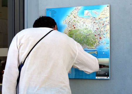 Sete, Herault, France  - Aug 21 2017: Man, a tourist, looking at a street map of Sete in Languedoc, Franceのeditorial素材