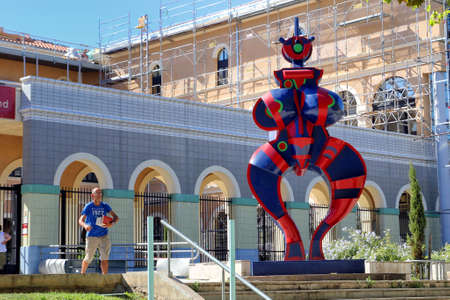 Sete, Herault, France  - Aug 21 2017: Man with books leaving the Mediatheque (Library) Francois Mitterrand  in Sete, Languedoc, France, next to the statue "Standing Woman" (renovated 2016)  by Joseph Szabo (1925-2010)のeditorial素材