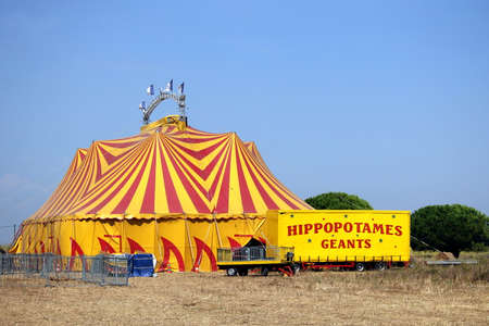 Valras-Plage, Herault, France - Aug 23 2017: Colourful red and yellow Circus Big Top in France, plus a trailer carrying a "Giant Hippopotamus"のeditorial素材