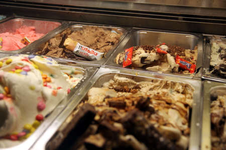 Valras-Plage, Herault, France - Aug 27 2017: Tubs of ice cream at an icecream parlour, featuring Smarties, Nutella, Daim and Snickers flavoursのeditorial素材