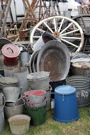 Group of old antique galvanised iron buckets and tin baths on display with various other vintage...