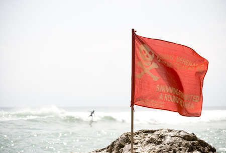 a no swimming warning flag red in colour on a beachの写真素材