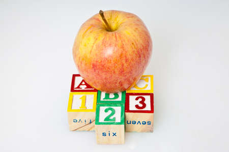 Education concept with children s blocks alligned in the alphabet and counting beside a red apple...