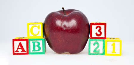 Education concept with children s blocks alligned in the alphabet and counting beside a red apple for the teacher の写真素材