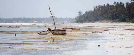A dow sits on the East Coast of Zanzibar waiting for High Tide. Tanzania