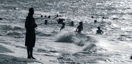 Local children play in the surf outside Stonetown. Zanzibar, Tanzania