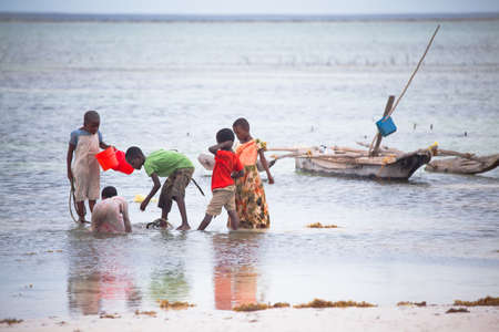 A group of children play in the tidal pools of the Indian Ocean. Zanzibar, Tanzaniaのeditorial素材