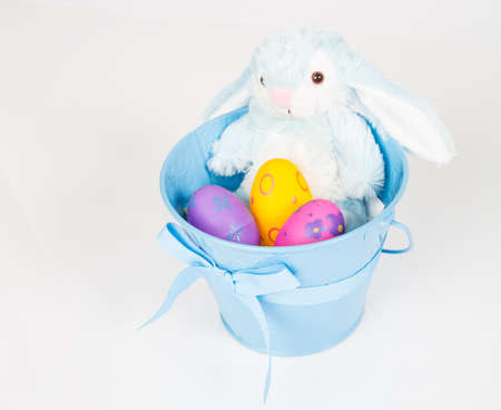 Easter Pail filled with toys, eggs, and candy. Isolated on a white background.の写真素材