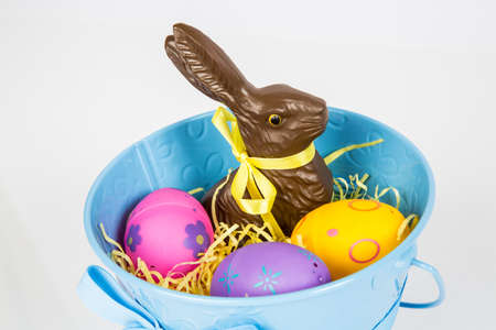 Easter Pail filled with toys, eggs, and candy. Isolated on a white background.