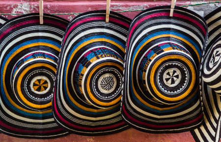 Stacks of colorful hats line the sidewalks in Cartagena's old city tempting tourists.の写真素材