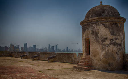 Caratgena's old city wall and watch towers with the new condo towers of Bocagrande in the background.の写真素材