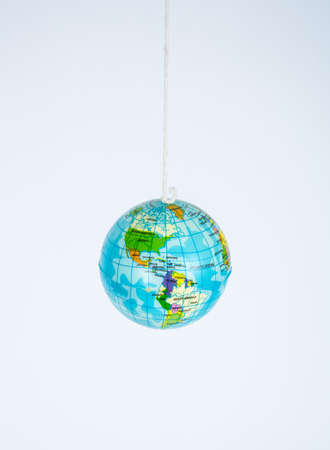 A small toy globe suspended on a string.の写真素材