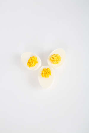 Three Devilled eggs arrainged on a white background.の写真素材
