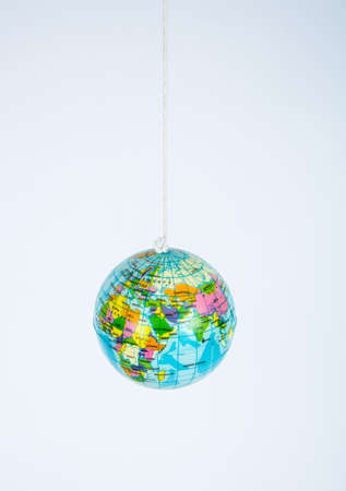A small toy globe suspended on a string.の写真素材