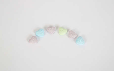 Valentine's candy conversation hearts with simple words of love on them arrainged in a curve.の写真素材