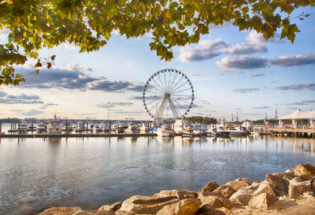 September 10, 2017, Oxen Hill, Maryland, USA: Boats dcked on the national waterfront sit in front of the pier and ferris wheeel in late summer.のeditorial素材