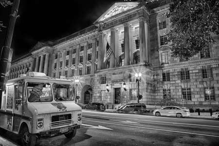 September 12, 2017, Washington, DC, USA: The US Department of Commerce  building, at night with a food truck parked in front. Symbol of big versus small commerce.のeditorial素材