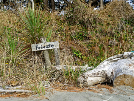 Private sign on a sandy west coast beach, New Zealand.の写真素材
